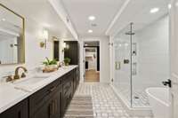 This master bathroom features double vanities and plenty of storage space along with a beautiful tile shower.