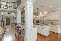 Open floor plan as kitchen opens to living room, foyer, and breakfast area.