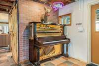 The itemized list of furniture and decor that's all available for separate purchase includes fun and funky details -- like this piano that doubles as martini-glass storage, topped with taxidermy and neon.