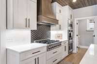 Gold and black tiled backsplash is the perfect feature wall in this kitchen... absolutely stunning!