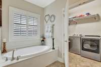 View from primary bath to private laundry room~Folding table with opening below for laundry baskets.