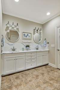 Primary bath has raised height double vanities~Cambia countertop and accent mirrors are recent updates/upgrades~Linen closet & Water closet.