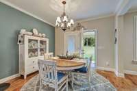 Informal dining area opens to covered back porch~French doors have encased blinds for ease~Open the blinds and enjoy a view of the treelined back yard~Built-in planning/homework desk is to the left of this picture.