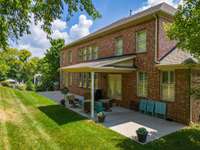 A full view of the full-length patio~Ample room to add an outdoor kitchen or hottub~Private backyard backs to mature treeline.