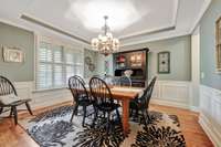 Formal dining room has tray ceiling & wainscotting~Plantation shutters are throughout the house.