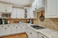 Another view of the kitchen workspace~Gas cooktop~Double ovens~Microwave~French door refrigerator~Dovetail drawer construction with full extension~All cabinets have double roll-out shelving.