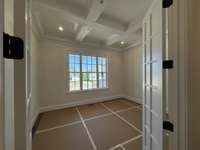 Enjoy this Study with a large window, french doors and coffered ceiling.