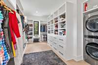 Primary suite walk in closet with laundry