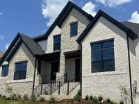 Gorgeous elevation with a mixture of stone and brick. Black windows add to the elegant and modern feel.