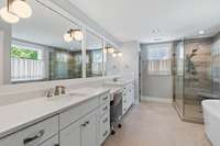 Retreat-style living continues in the Primary bathroom! Notice the length of the countertops! Tiled walk-in glass shower, soaking tub, linen closet, and toilet room.