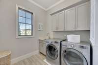 The laundry room, on the east side of the home, has a utility sink and plenty of storage space with cabinets.