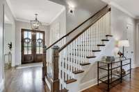 Classic newel posts with white balusters and hardwood treads create a stairway focal point from the main floor.