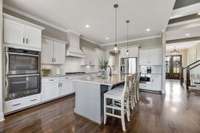 The smartly designed kitchen is finished with timeless white cabinets, a gas range and a double built-in oven.