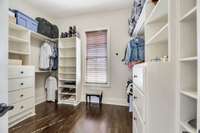 The primary closet has site-built cabinetry with shelves, drawers and abundant hanging space for two.