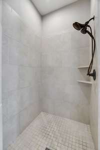 The primary shower is completed with a light tile floor providing plenty of reflected light.