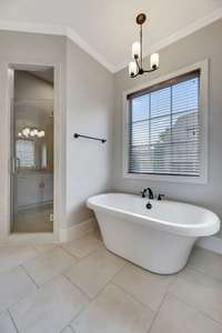 The light colored bathroom tile and walls present a clean and pleasant background for the relaxing stand-alone tub.