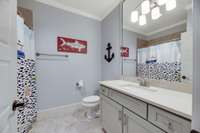 A tiled tub/shower combination and light colored vanity are found in the third bedroom bath.