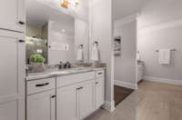 Round the corner in the dressing room to the primary bath suite. Gorgeous quartz on the large double vanities.