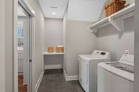 A large laundry room with folding table, hanging rod and extra storage.