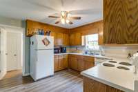 The kitchen has laminate flooring, ceiling fan, refrigerator, dishwasher & stove.