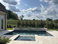 Resort-style covered outdoor living area with fireplace and outdoor kitchen overlooking fabulous Pool / Spa.