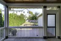 View of the back deck and backyard from the screened in patio.