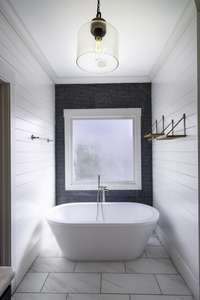 Soaking tub in the primary bathroom which also boasts shiplap walls.