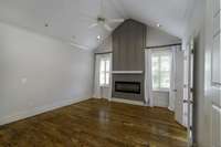 Main floor primary suite with custom accent wall feature and electric fireplace.