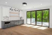 Upper-level wet bar in recreation room that leads to Large outdoor deck