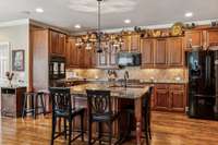 Very spacious kitchen with large island, double ovens, gas cooktop and undercabinet lighting