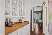 Butler's Pantry with custom butcher block countertop and upper glass cabinet doors. The right wall includes molding and sconces to highlight your favorite art pieces or family photos.