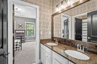 Jack and Jill Bathroom with double vanities, fresh lighting, and paint design detailing.