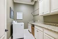 The laundry room has plenty of counter space and cabinet storage, along with a laundry chute from the upstairs hallway - so convenient!