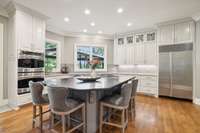 This oversized kitchen island offers plenty of room for serving, gathering and dining, all while enjoying beautiful views of the lovely backyard area.