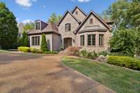 The circular driveway and beautifully established landscaping provide a picturesque setting for this elegant home.