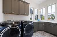 Main level laundry room with cabinet & counter space