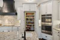 You will love this hidden oversized walk-in pantry & double ovens