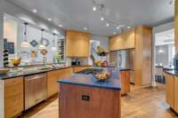 The flat panel stained cabinets contrast beautifully with the gleam of the stainless steel appliances.