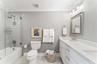 Bathroom in the hallway upstairs has a tiled shower and glass enclosure door.