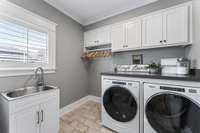 Laundry room with utility sink & cabinet storage & folding station