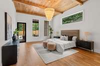 Gorgeous primary bedroom with plank ceiling and lovely fringed chandelier overlooks pool