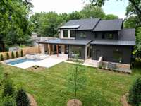 View of handsome home, pool, spa, outdoor kitchen and expansive backyard. Fence has been painted to match color of the home.