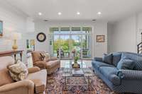 Sliding French doors lead to another outdoor living area, equipped with an electronic all-seasons screen.