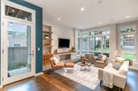 Sunken living/family room with expansive windows and tons of natural light. This room includes built in cabinets, speakers, and ethanol fireplace. Television and built in speakers remain.