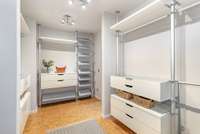 Walk in primary closet, with built in storage and cork floors.