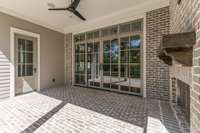 Double sliding doors open to outdoor patio/fireplace and custom hardscaping + landscaping.