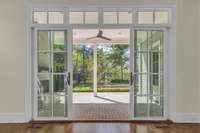 Double sliding doors open to outdoor patio/fireplace and custom hardscaping + landscaping.