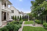 English garden-inspired outdoor design with custom trellis work and mature plantings adds depth and privacy to the setting.