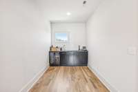 Small entertaining space large enough for pub table or bistro table/chairs. Wet bar: sink, under mount beverage cooler, solid surface top.