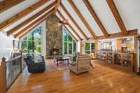 2-story stone fireplace and a wall of windows overlooking mature trees and lake views! This room has 1 of 2 gas fireplaces in the room.